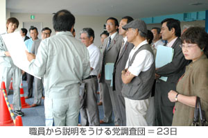 職員から説明をうける党調査団=23日